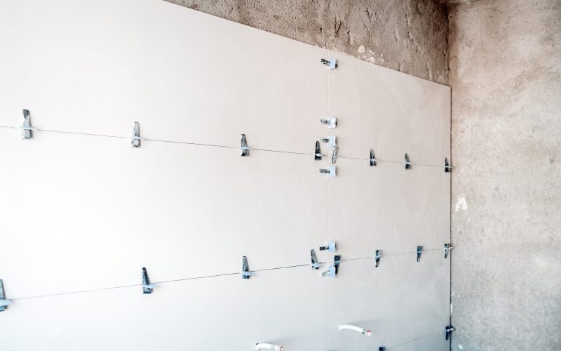 construction site. white modern tiles on bathroom with separator and leveling during works. Home renovation